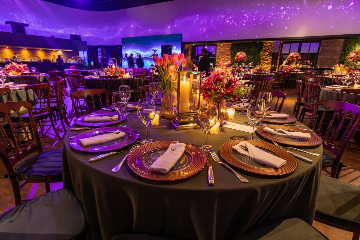 Event hall with candlelit round tables styled for a corporate team building evening